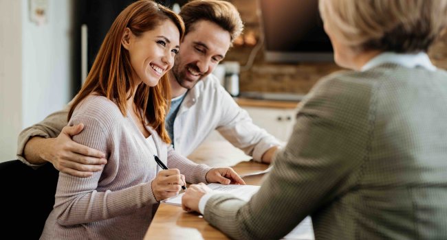 jeune-femme-heureuse-son-mari-signant-accord-agent-assurance-lors-reunion (1)